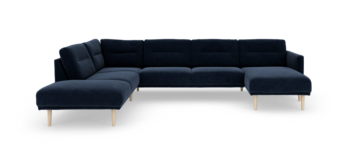 Mørkeblå modul-hjørnesofa med chaiselong til højre og lyse træben, frilagt på hvid baggrund.