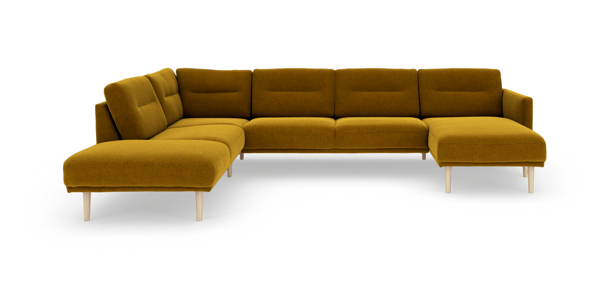 Modulær hjørnesofa i sennepsgult stof med chaiselong til højre og lyse træben, frilagt på hvid baggrund.