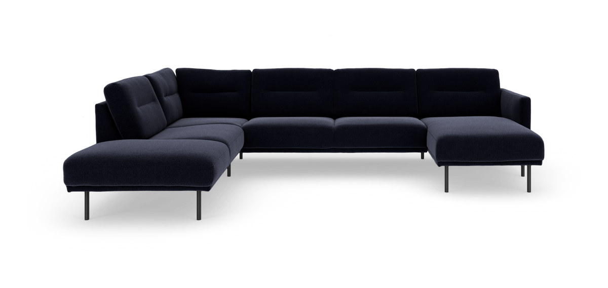Mørkeblå modulsofa i L‑form med chaiselong til højre, slanke metalben, frilagt på hvid baggrund.