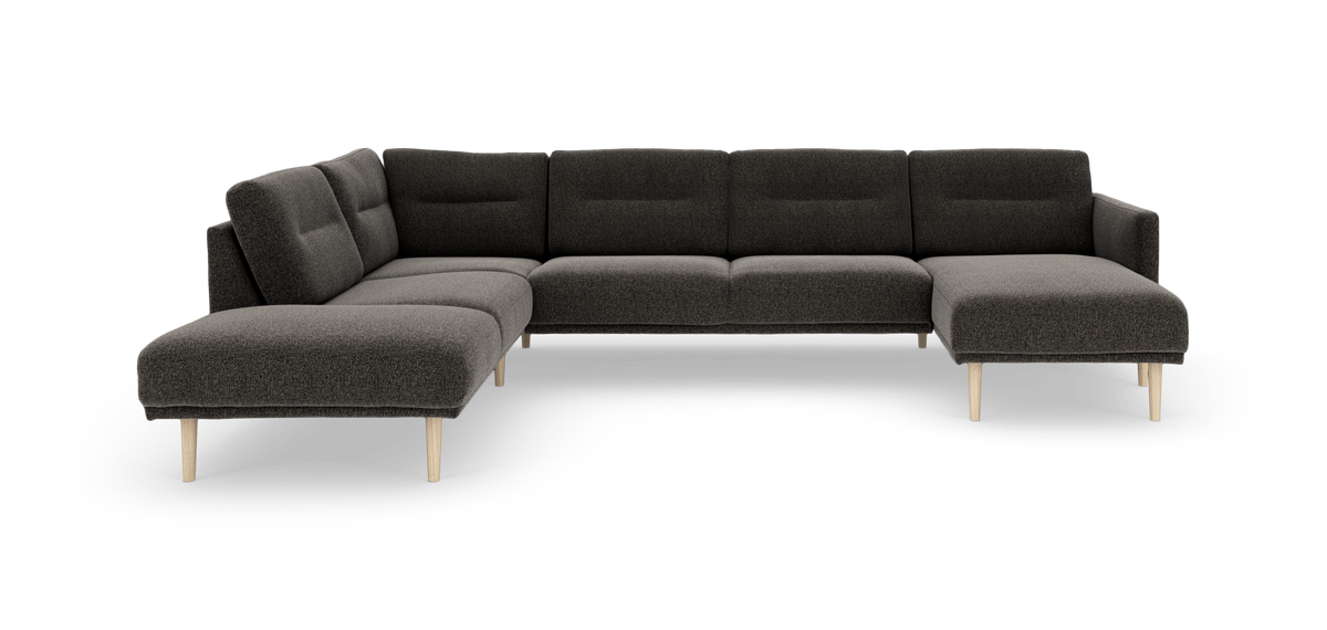 Mørkegrå modulsofa i hjørne/U‑form med chaiselong og lyse træben, fritlagt på hvid baggrund.