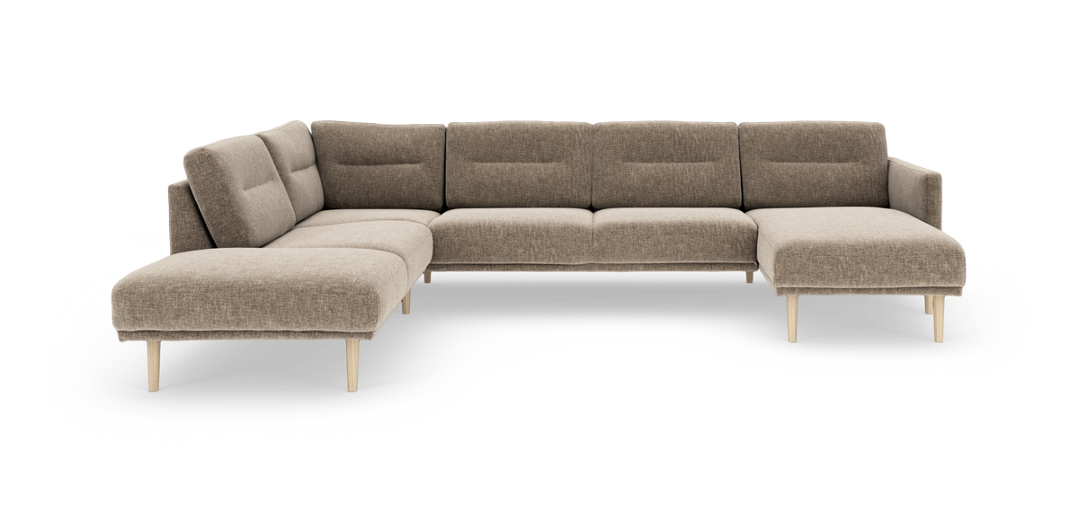 Beige modulsofa i vinkel med chaiselong og lyse træben.
