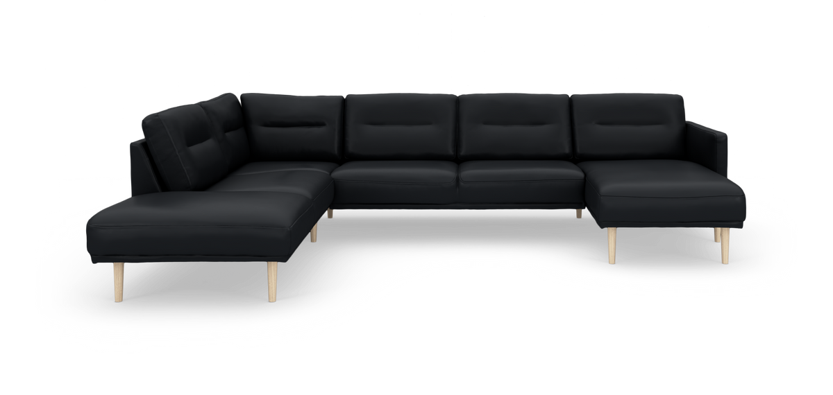 Sort hjørnesofa/U‑sofa med chaiselong i begge ender og lyse træben, frilagt på hvid baggrund.
