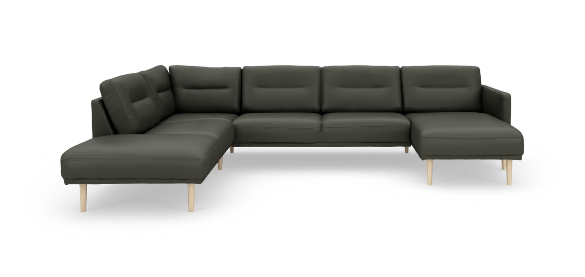 Mørkegrøn modulær hjørnesofa med to chaiselonger og lyse træben, frilagt på hvid baggrund.