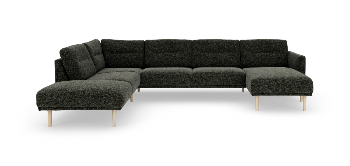 Mørkegrå modulsofa i U‑form med chaiselong til højre og lyse træben, frilagt på hvid baggrund.