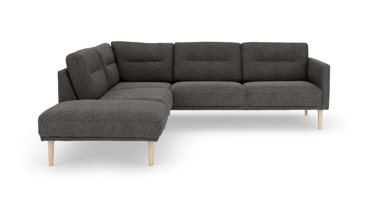 Mørkegrå hjørnesofa med venstrevendt chaiselong, tuftede ryghynder og lyse træben.