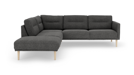 Mørkegrå hjørnesofa med venstrevendt chaiselong, tuftede ryghynder og lyse træben.