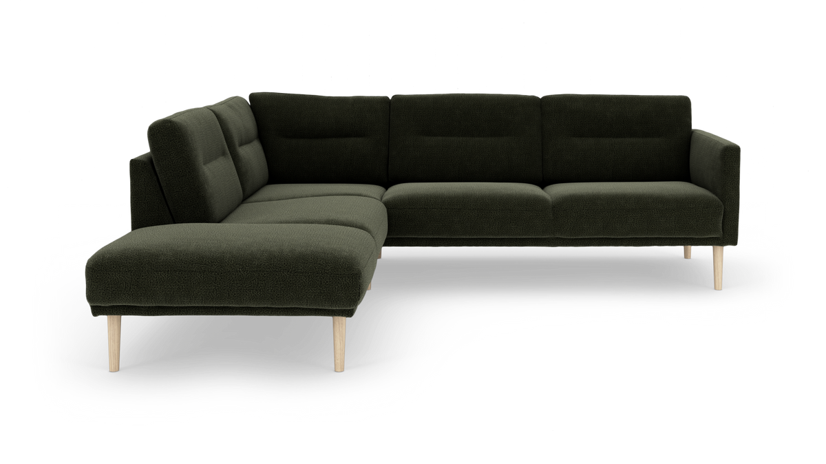 Mørkegrøn modulær hjørnesofa med chaiselong og lyse træben, frilagt på hvid baggrund.
