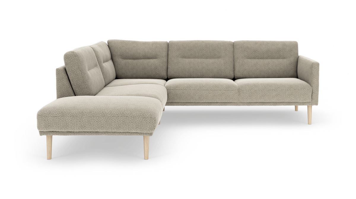 Beige L‑formet hjørnesofa med venstre chaiselong og lyse træben, polstret i bouclé-stof.
