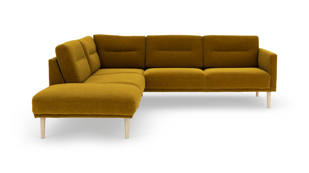 Hjørnesofa i sennepsgul tekstil med træben, L‑form med chaiselong til venstre.