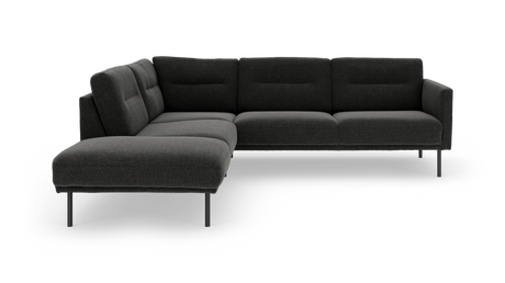 Mørkegrå L‑sofa med chaiselong, polstrede ryglæn og slanke metalben, frilagt mod hvid baggrund.