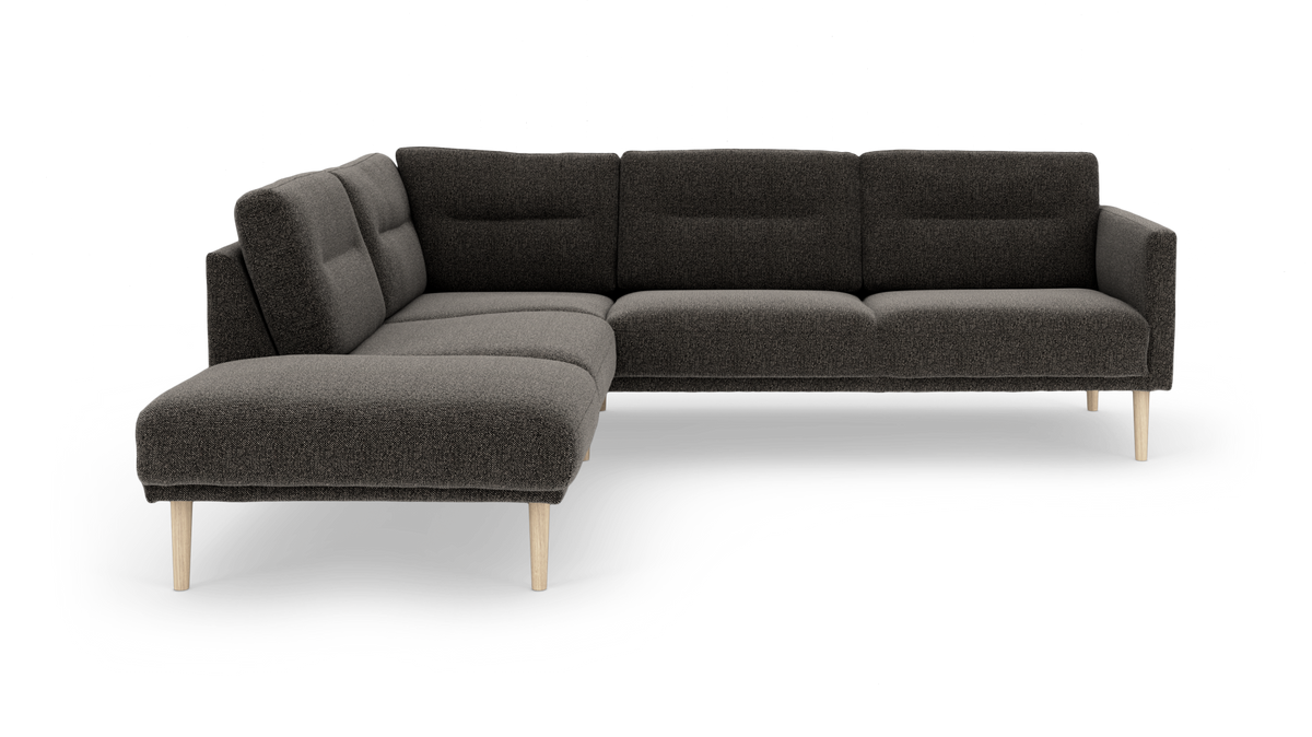 Mørkegrå L‑formet modulsofa med træben, frilagt på hvid baggrund.
