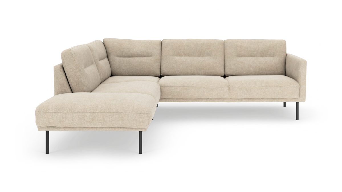 Beige L-formet modulsofa med slanke sorte ben, fire sæder og chaiselong til venstre, fritlagt på hvid baggrund.
