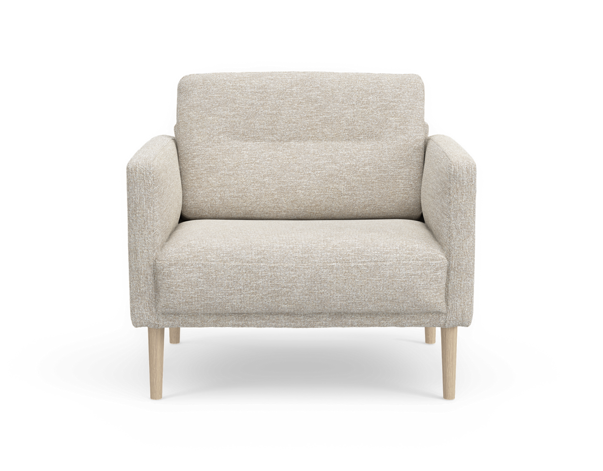 Beige lænestol med blød polstring og afrundede armlæn samt lyse træben, set forfra mod hvid baggrund.