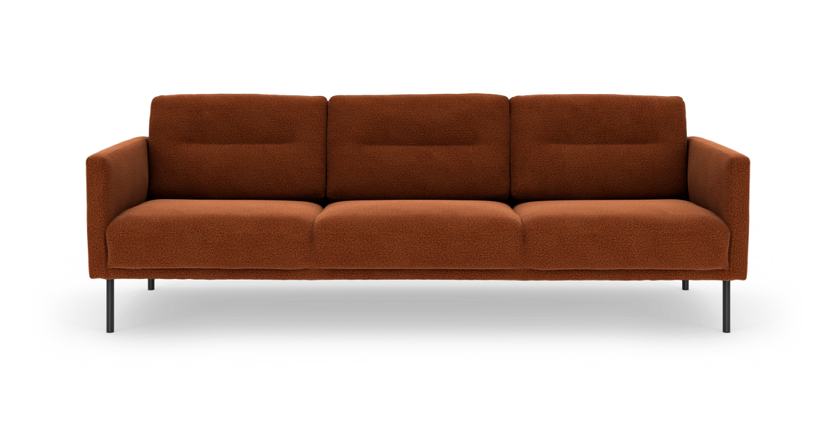 Tremoduls sofa i rustrød bouclé med slanke sorte ben, frontvisning.