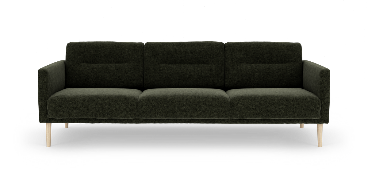 Mørkegrøn tresæders sofa med lyse træben, frontvisning på frilagt baggrund.