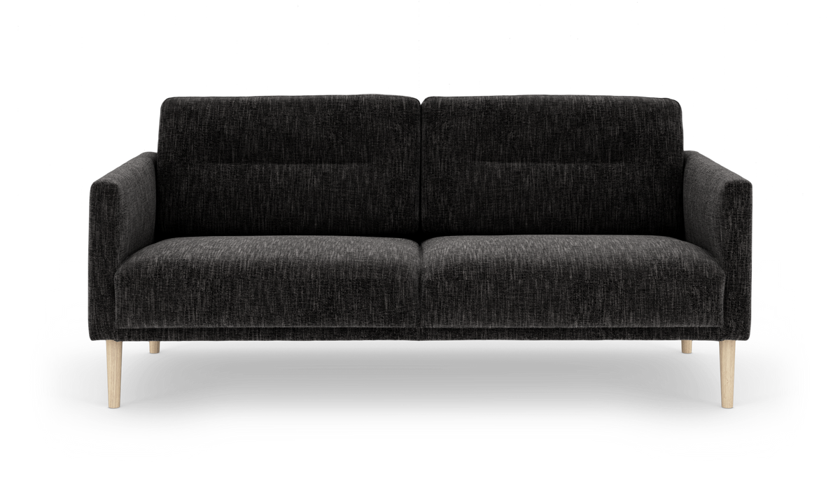 Mørkegrå stofsofa med lyse træben, frilagt på hvid baggrund.