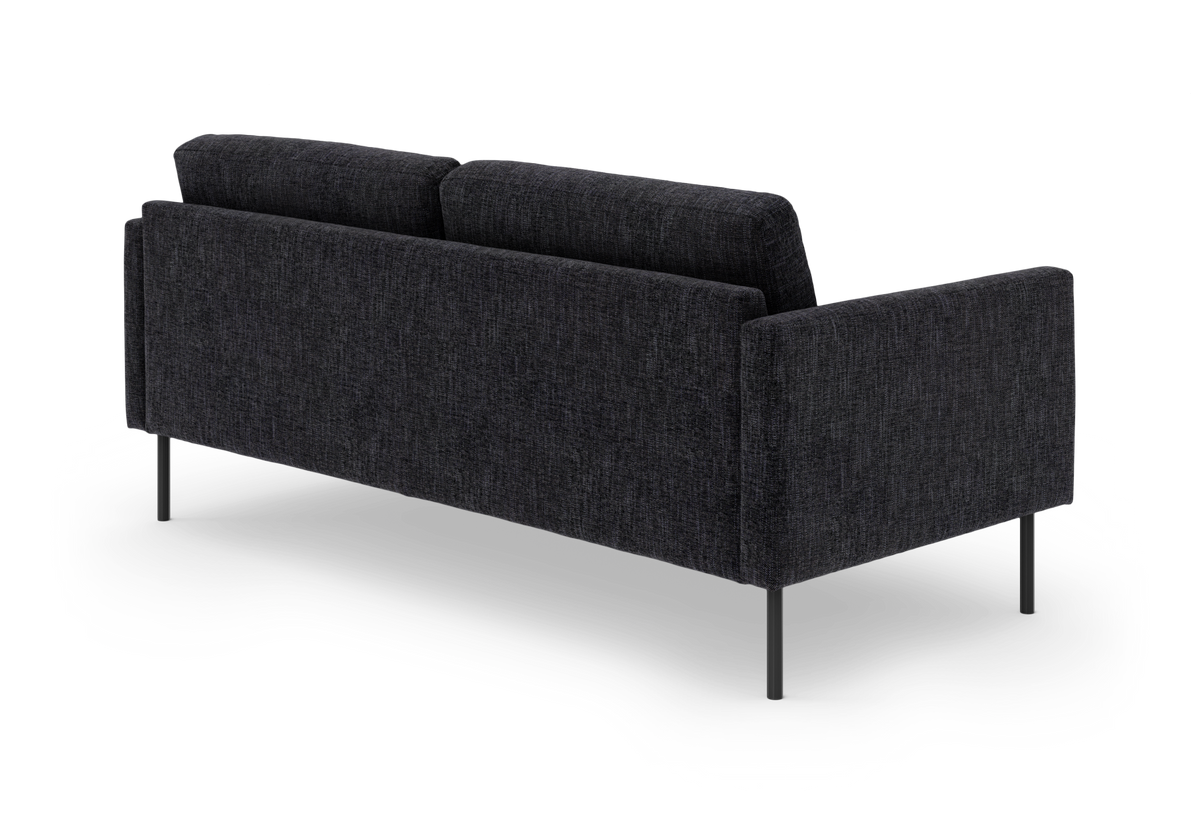 Mørkegrå stofsofa set bagfra i skrå vinkel, fritstående mod hvid baggrund.