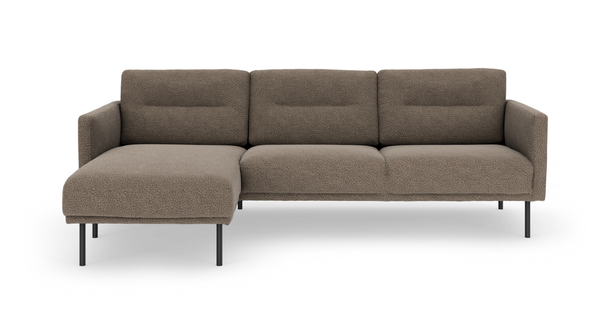 Beige hjørnesofa med venstrevendt chaiselong og slanke sorte ben i frontvisning, frilagt baggrund.