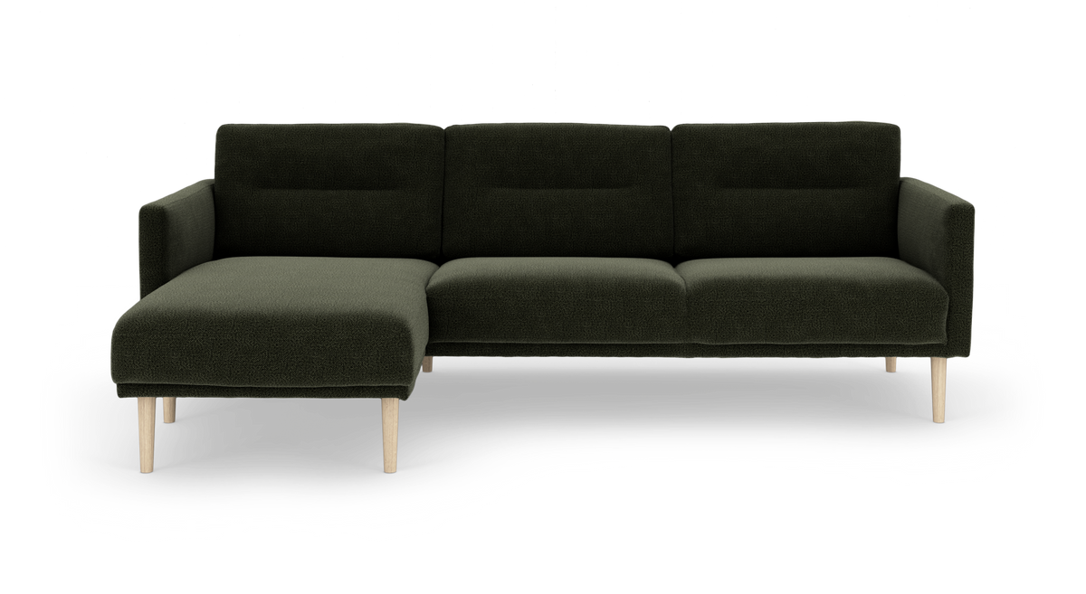 Mørkegrøn modulsofa med venstrevendt chaiselong og lyse træben, fritstående på hvid baggrund.