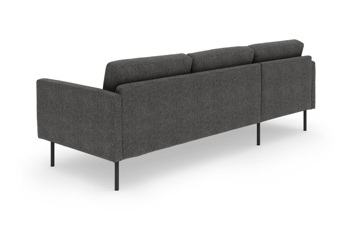 Mørkegrå, moderne 3-personers sofa på slanke sorte metalben, set skråt bagfra på hvid frilagt baggrund.