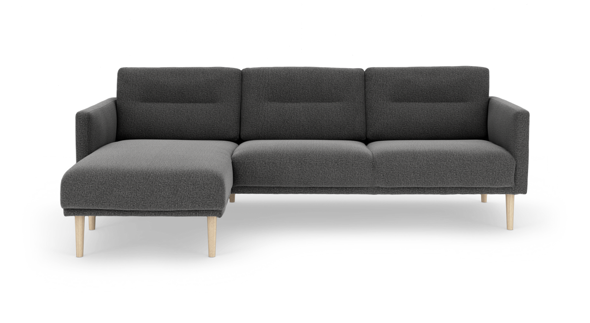 Mørkegrå sofa med venstrevendt chaiselong og lyse træben, fritlagt på hvid baggrund.