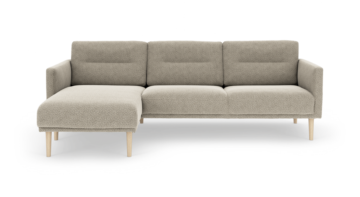 Beige modulsofa med venstrevendt chaiselong og lyse træben, frontvisning på hvid baggrund.