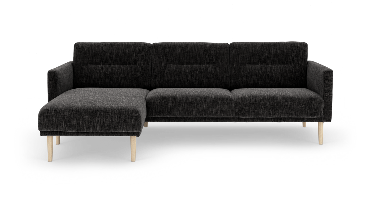 Mørkegrå hjørnesofa med venstrevendt chaiselong og lyse træben, frilagt på hvid baggrund.