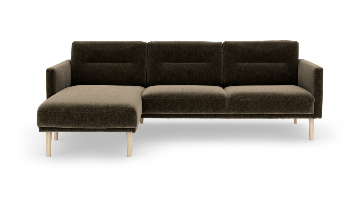 Mørkebrun L‑sofa med venstre chaiselong og lyse træben, fotograferet forfra på hvid baggrund.