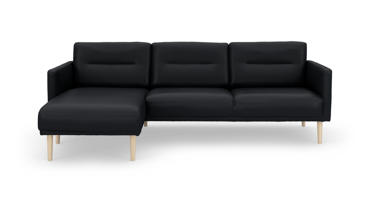 Sort hjørnesofa med venstre chaiselong og lyse træben, frilagt på hvid baggrund.