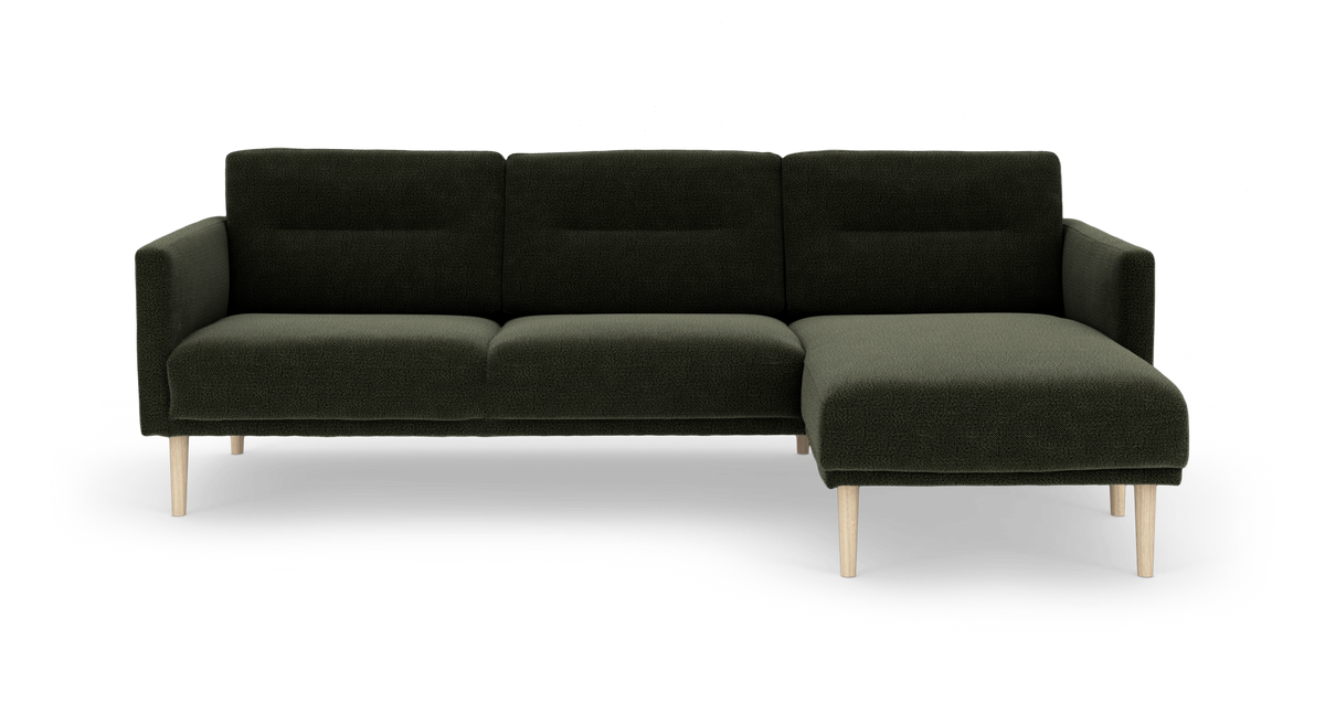 Mørkegrøn modulsofa med højre chaiselong og lyse træben.
