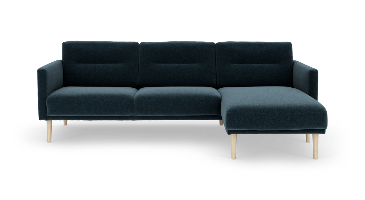 Mørk petrolblå 3-personers sofa med højre chaiselong og lyse træben, frilagt på hvid baggrund.