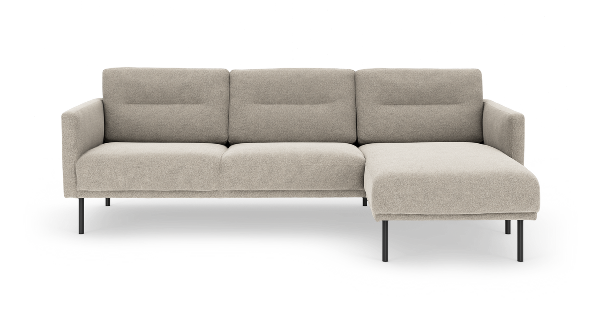 Beige modulsofa med højrevendt chaiselong og slanke sorte ben, fotograferet lige forfra.