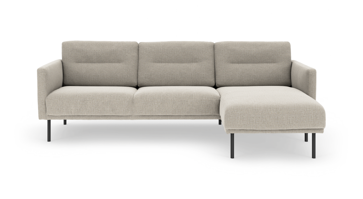 Beige modulsofa med chaiselong på højre side og slanke mørke ben, fritstående på hvid baggrund.