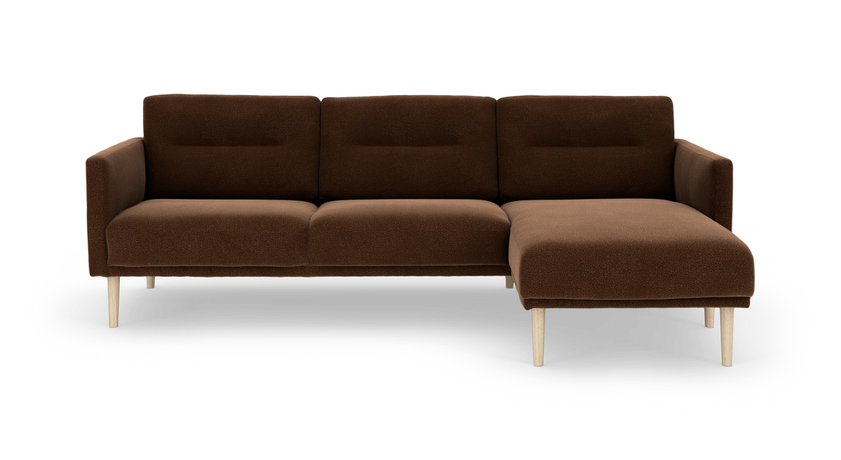 Brun modulsofa med chaiselong til højre og lyse træben, fotograferet forfra.