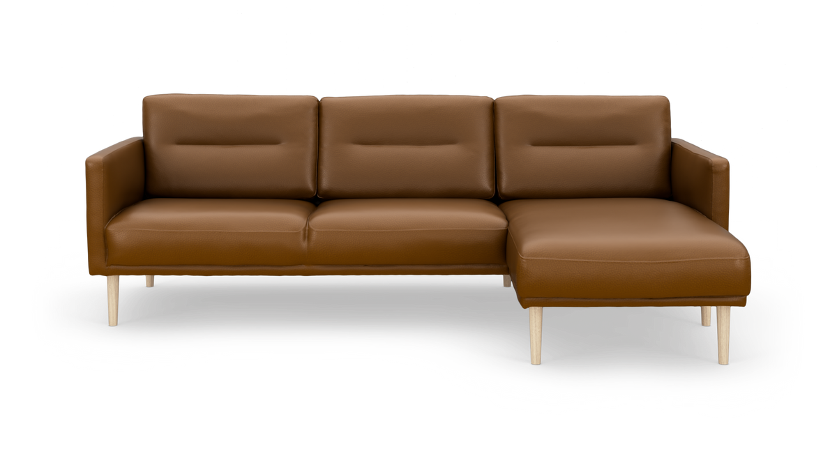 Brun lædersofa med chaiselong til højre og lyse træben, frontvisning frilagt.