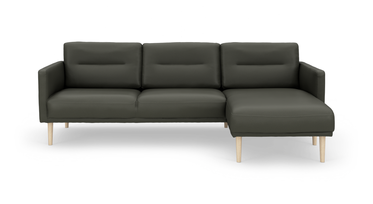 Mørkegrøn hjørnesofa med højrevendt chaiselong og lyse træben, frilagt på hvid baggrund.