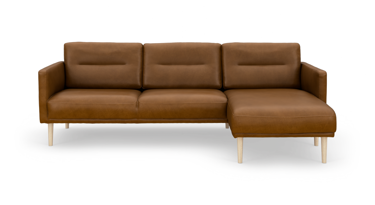 Brun lædersofa med højrevendt chaiselong og lyse træben, frilagt på hvid baggrund.