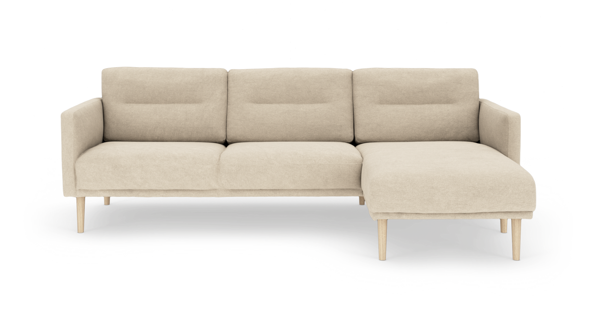 Beige 3-personers sofa med højrevendt chaiselong og lyse træben, moderne og minimalistisk, fritlagt på hvid baggrund.