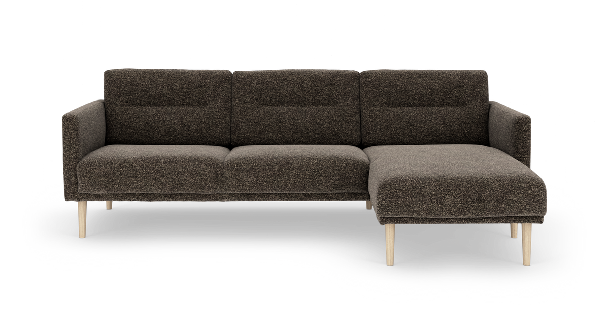 Mørkebrun modulsofa med chaiselong til højre og lyse træben, frilagt på hvid baggrund.