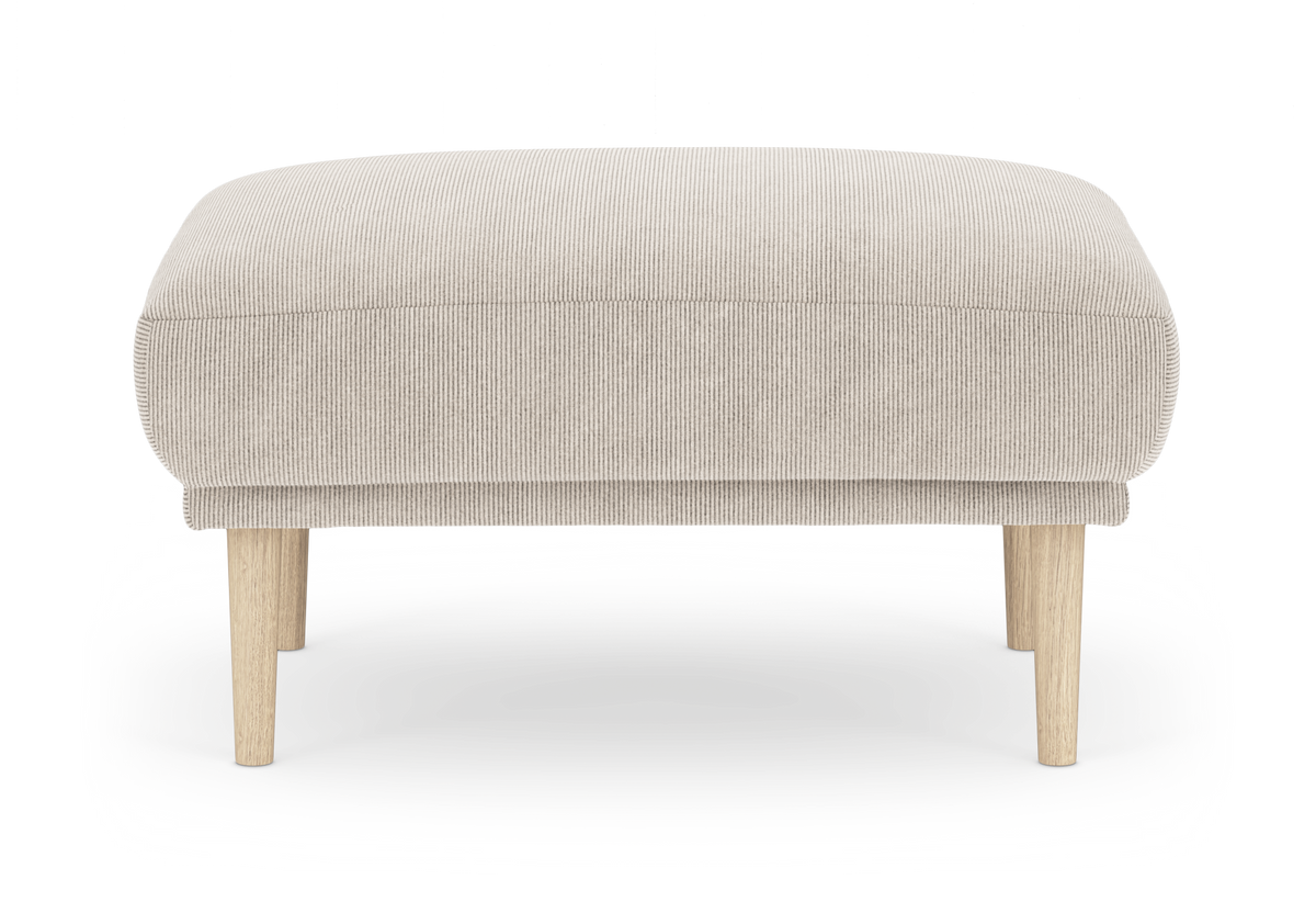 Beige ottoman i fløjl med lyse træben, frontalt produktfoto.