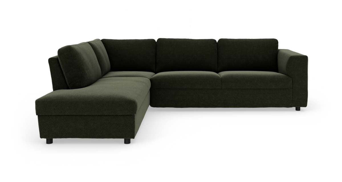Mørkegrøn L-formet hjørnesofa med chaiselong til venstre, bløde puder og korte sorte ben på hvid studiebaggrund.