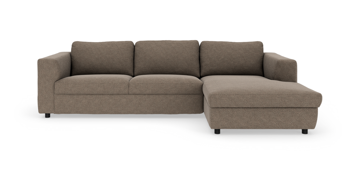 Brun hjørnesofa med chaiselong til højre, moderne lav profil med brede armlæn.