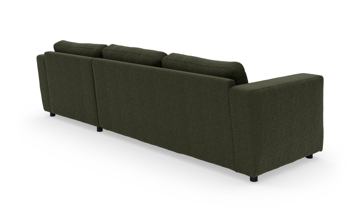 Mørkegrøn stofsofa med tre ryghynder, set skråt bagfra på hvid studiobaggrund.