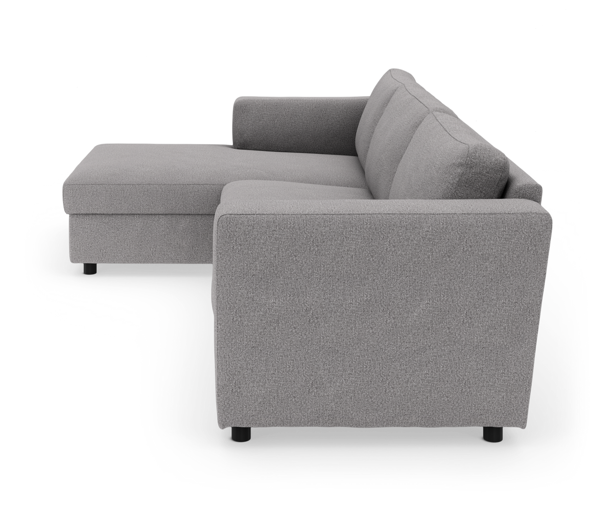 Grå L-formet sofa med venstrevendt chaiselong i stof, set skråt bagfra fra siden.