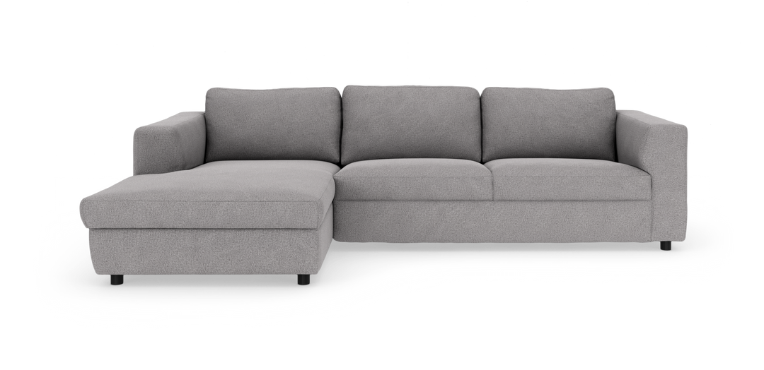 Lysgrå hjørnesofa med venstrevendt chaiselong, tre ryghynder og brede armlæn.