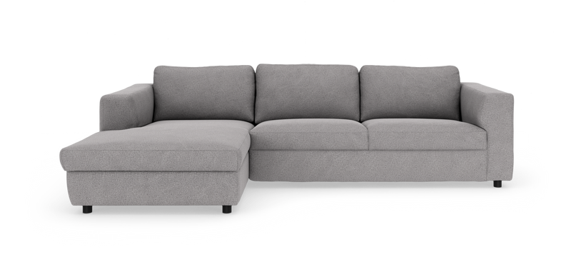 Lysgrå hjørnesofa med venstrevendt chaiselong, tre ryghynder og brede armlæn._ps
