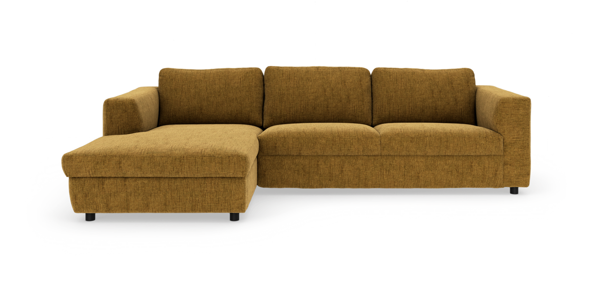 Sennepsgul hjørnesofa med venstrevendt chaiselong, fire ryghynder og sorte ben, frilagt i studie.