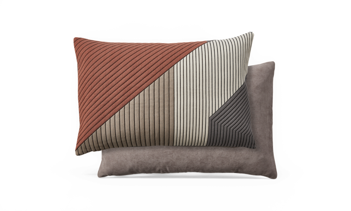 To pyntepuder; den forreste med rillet geometrisk mønster i rust, beige, creme og mørkegrå, den bagerste i ensfarvet grå velour.