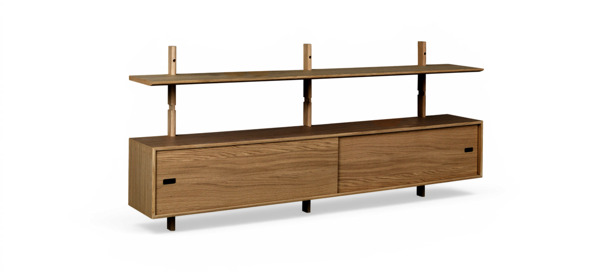 Vægmonteret egetræshylde med skydedørsskab og øverste hylde, minimalistisk design.