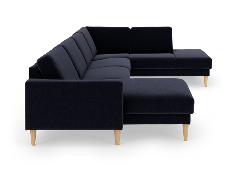 Mørkeblå hjørnesofa i stof med chaiselong og lyse, koniske træben.